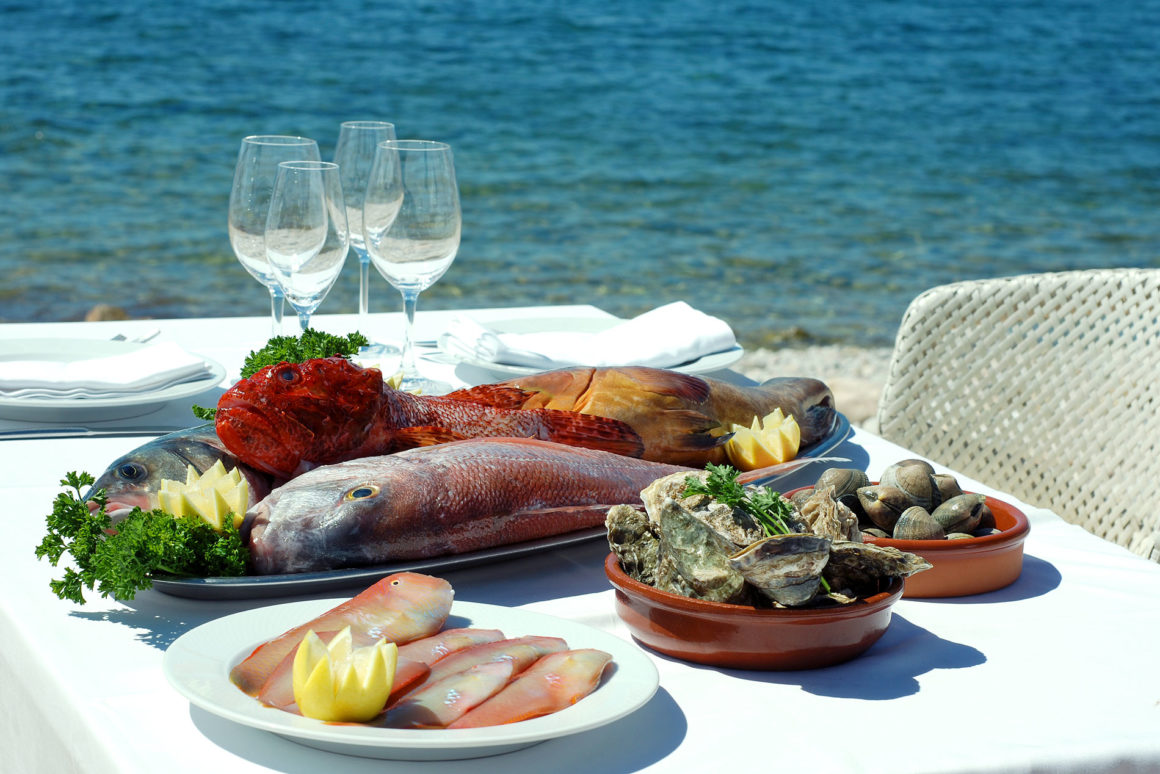 restaurant Ibiza met zicht op zee en mooie visschotel op tafel 