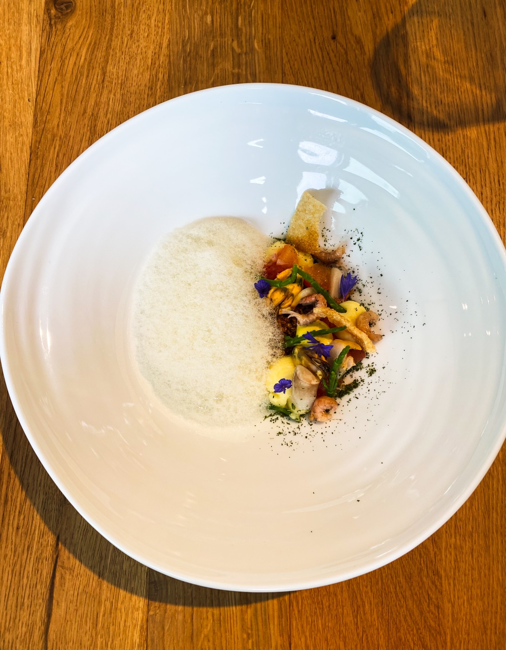 Een culinaire ode aan 'De Noordzee' gepresenteerd op een bord, met smaken van Beurre Noisette, garnaaltjes, zeekraal en aardappel, een zeevruchtendroom tot leven gebracht in Restaurant Dante.