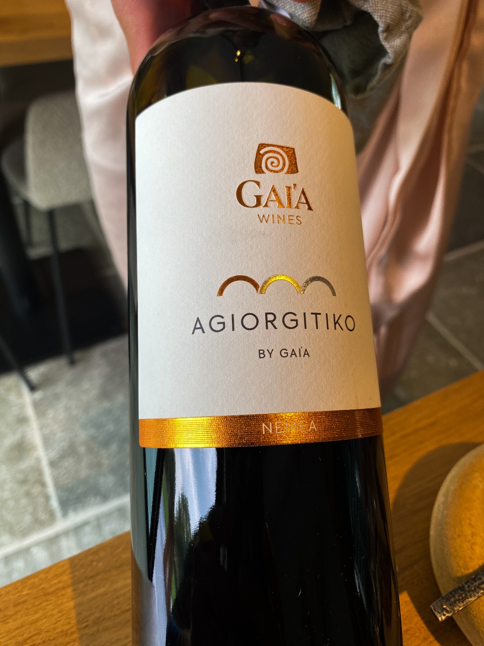 Een elegante fles Gaia 'Agiorgitiko', een rijke rode Griekse wijn, straalt kwaliteit en diepte uit, klaar om te worden gedronken en genoten in Restaurant Dante.
