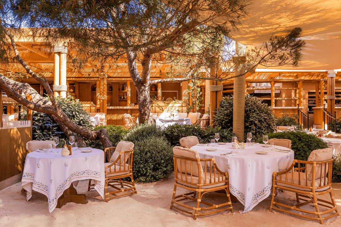 Oase van rust onder de dennenbomen bij Gigi Beach Bar in Ramatuelle, Saint-Tropez, perfect om te ontspannen en te genieten van heerlijke Italiaanse gerechten.