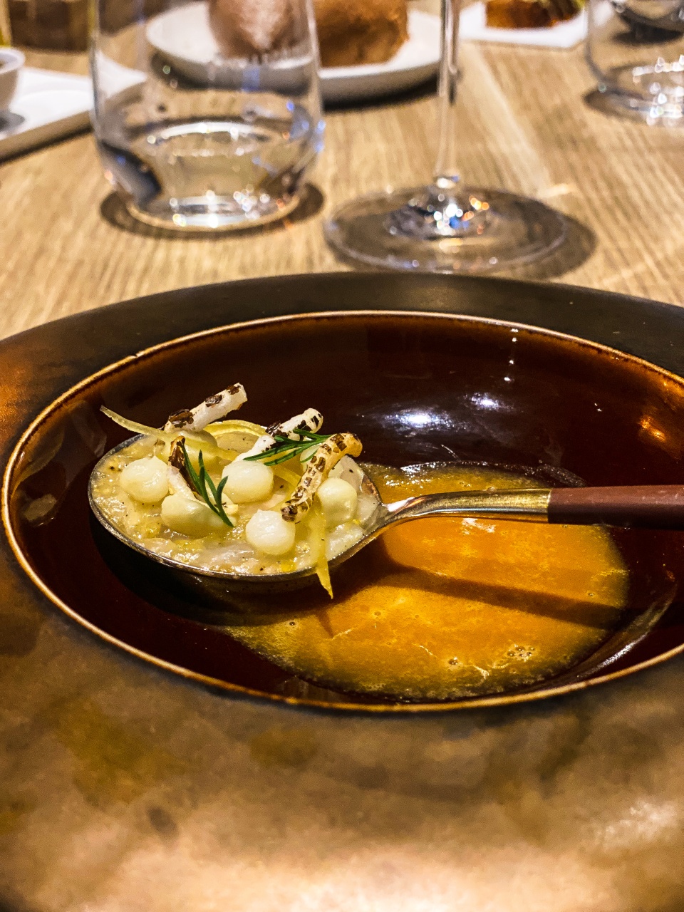 Een verleidelijk duo van krab, vakkundig bereid in twee yuzu-varianten, gepresenteerd op een kunstzinnig bord, weerspiegelt de inventiviteit en vakmanschap van Restaurant Zappaz in Leuven