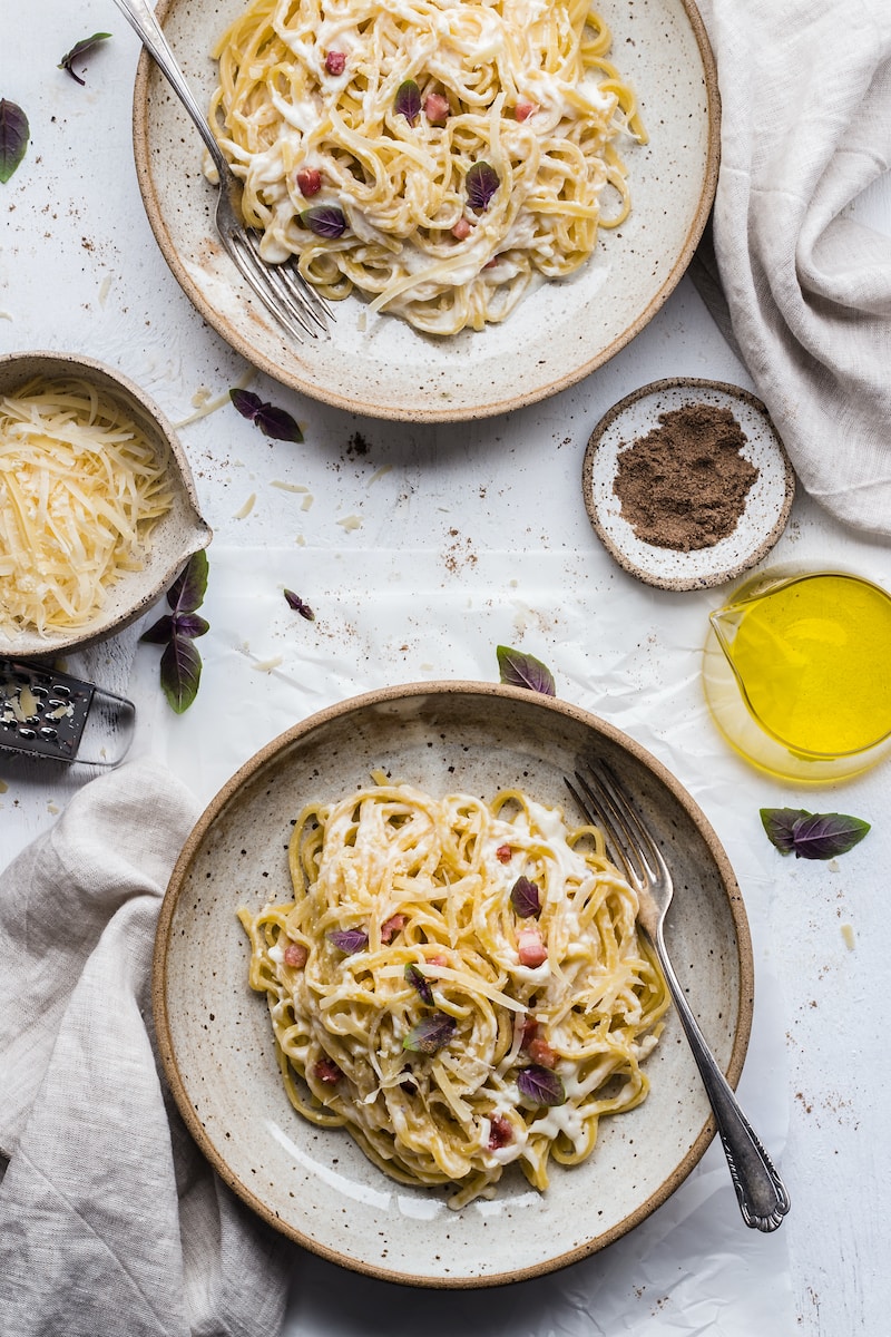 Een smakelijk bord pasta funghi, rijkelijk gegarneerd met vers gesneden champignons en fijngehakte peterselie, geserveerd in een diepe kom, waarbij de romige saus de noedels perfect omhult.