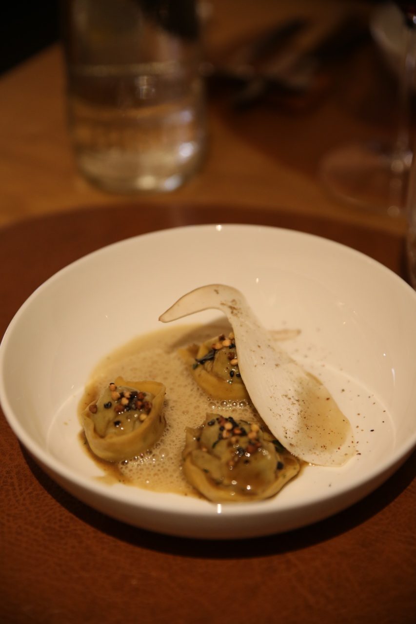 A tasty portion of ravioli served on an elegant plate. The ravioli, carefully filled with a rich filling, perhaps of ricotta or a delicate meat mixture, is perfectly cooked to an al dente texture. Each piece is neatly sealed, indicating craftsmanship and attention to detail. The sauce, perhaps a classic tomato sauce or a creamy variety, is draped generously over the ravioli and complements the filling beautifully. A few fresh herbs, such as basil or parsley, are sprinkled over the dish as a finishing touch, adding a touch of freshness and colour. 