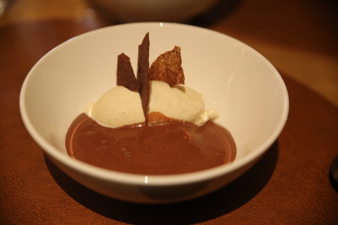 
A classic dame blanche dessert is visible with vanilla ice cream and chocolate sauce. There are also whipped cream and a wafer as garnish. The whole thing looks tempting and tasty.