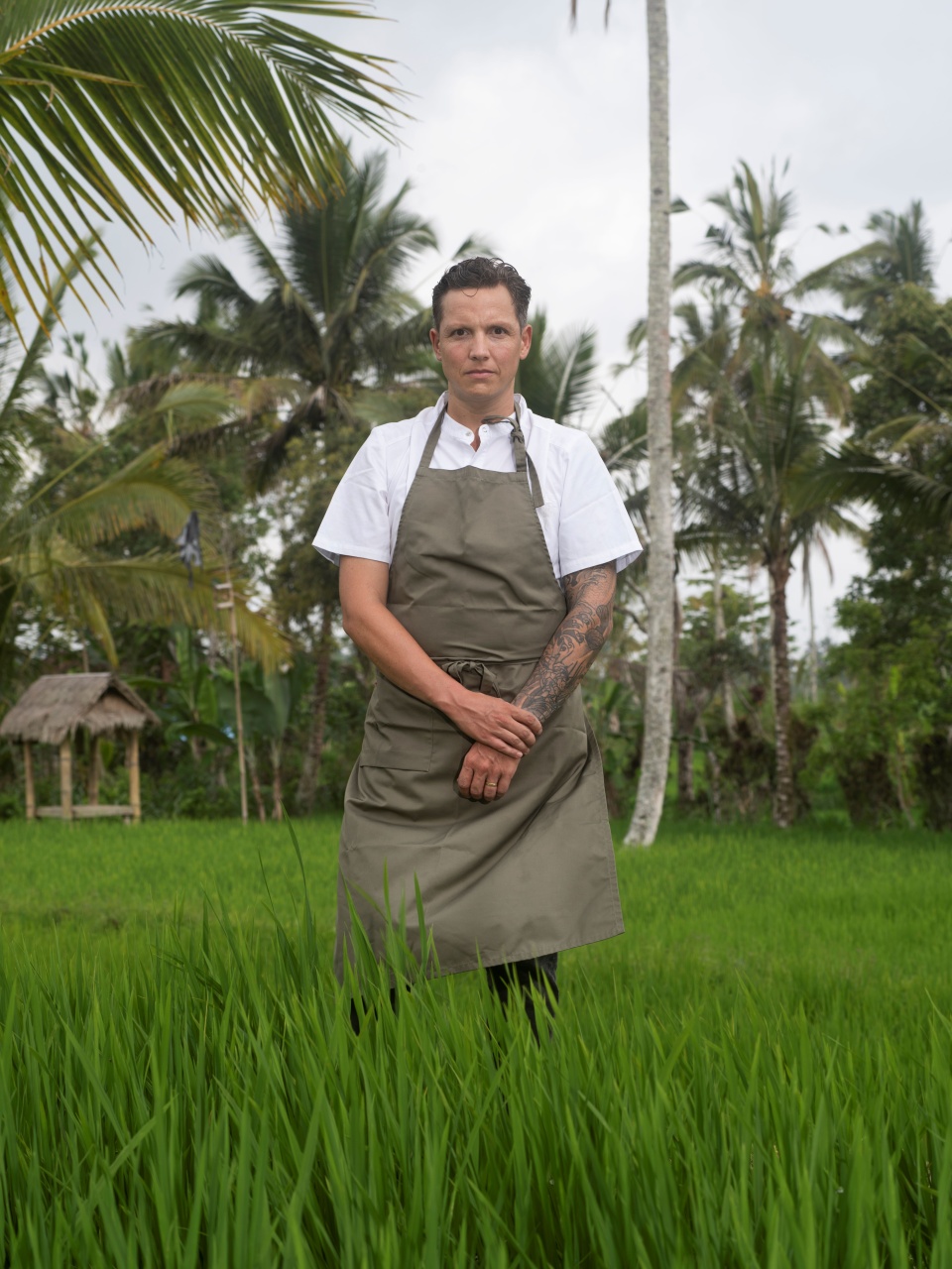 Chef-kok Syrco Bakker staat in een koksvest en schort midden in een groen rijstveld in Bal