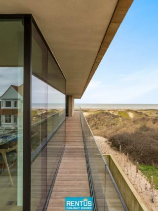 Zijdelings zeezicht vanaf het terras van Rêve des Dunes met zicht op de beschermde duinen en de horizon van de Noordzee.