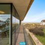 Zijdelings zeezicht vanaf het terras van Rêve des Dunes met zicht op de beschermde duinen en de horizon van de Noordzee.