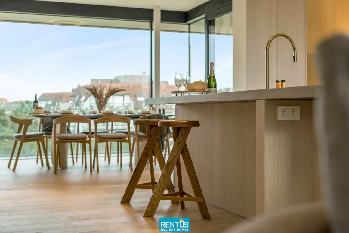 Open keuken in houttinten met kookeiland en hoogwaardige Miele-apparatuur.